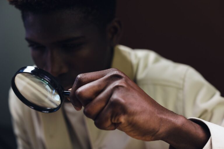 How to Detect and Remove Rootkits on Linux A man closely inspects an object using a magnifying glass.
