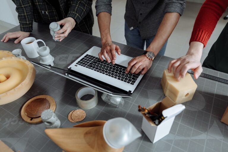Best CI/CD Tools for Small DevOps Teams Group collaborating on a design project using technology and crafts in a workshop.