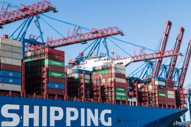 Docker vs Podman: Which Container Tool is Better Shipping containers and cranes at Hamburg port showcasing global trade.