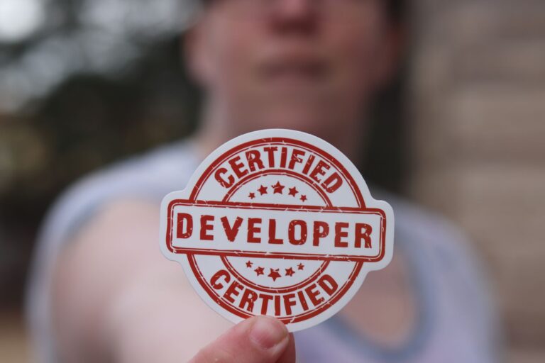Best IT Certifications for Sysadmins in 2026 Close-up of a certified developer badge being held outdoors.