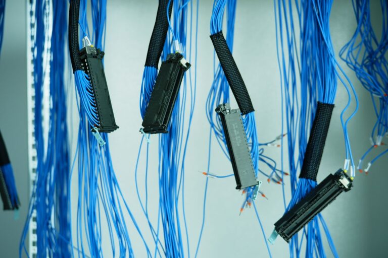How to Use Ansible for Server Automation Close-up of blue ethernet cables hanging in a data center, highlighting technology connections.